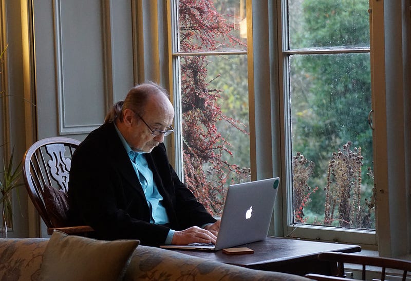 Elderly man looking at a computer screen with emails