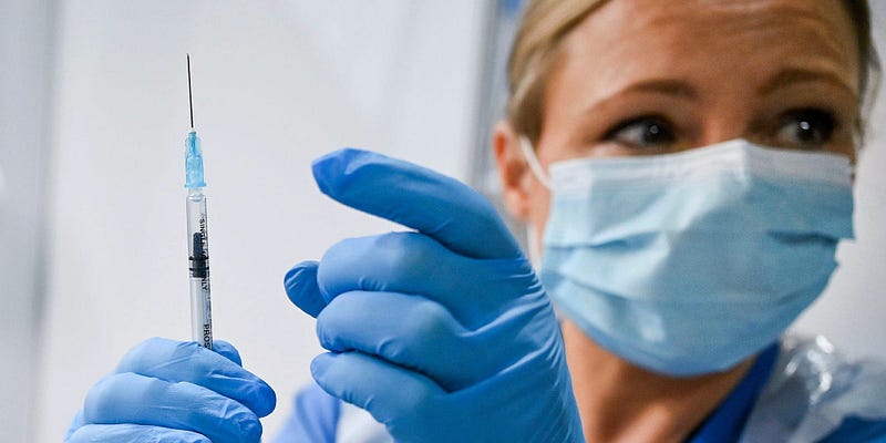 Health worker administering the Pfizer vaccine